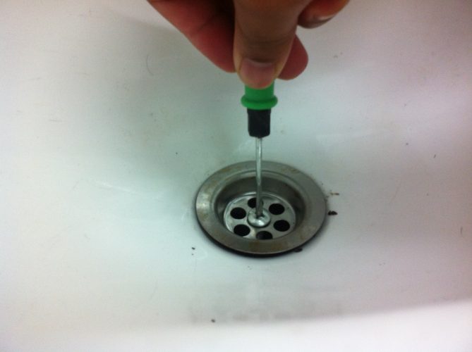 Membuka skru penutup singki